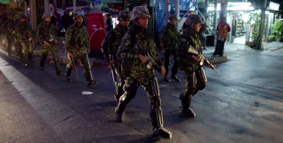 Image:  Thai soldiers in riot gear patrol the streets around the 'Red Shirt' fortified camp in downtown Bangkok