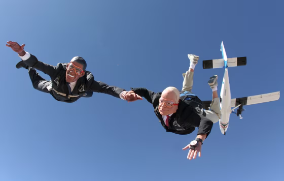 Image: Parachutists dressed as presidential candidates jump from a plane