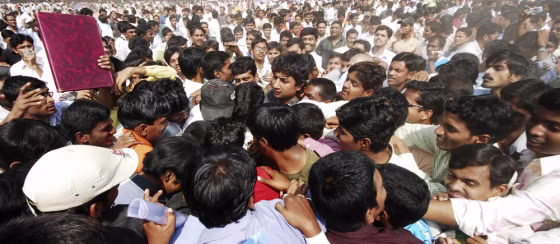 Image: Candidates seeking employment tussle for enrolment forms during a job fair in India