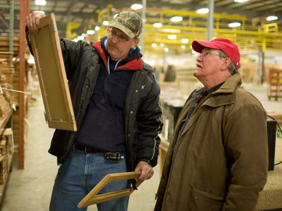 Greg Huber and Richard Eysol examine unused cabinet material that they just purchased at the auction of the Americamp RV factory. 
