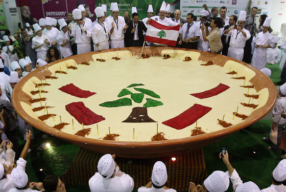 Lebanese chefs celebrate around their hummus creation in Beirut on Saturday. The tree and red bars are taken from the design of Lebanon's flag.