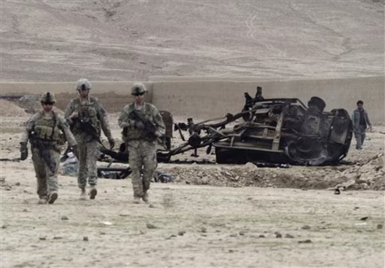 U.S.&nbsp;soldiers on patrol pass the wreckage of a car after an explosion in the Arghandab district of Kandahar province, Afghanistan on&nbsp;Sunday. Twin bomb blasts killed eight Afghans on Sunday at an illegal dog fight in the volatile south, officials said.