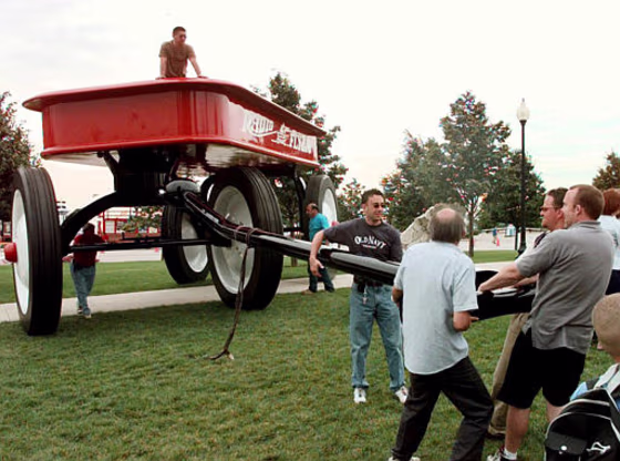Workers pull a giant Radio Flyer wagon into place at near Navy Pier in Chicago in June 2000. The world's biggest wagon was made by Chicago-based  Inc. to mark its 80th anniversary. It now plans to manufacture the iconic American toy in China, and will lay off nearly half of its 90 employees.