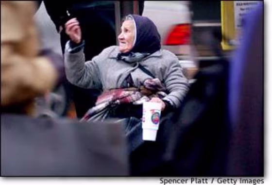 A homeless woman begs for change on Dec. 17 in New York, where homelessness is at record levels.