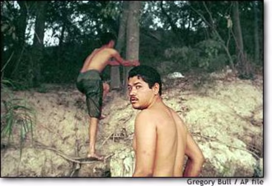 Two men, who declined to give their names, listen for approaching vehicles as they climb onto U.S. soil from the Rio Grande river near Laredo, Texas, in November.