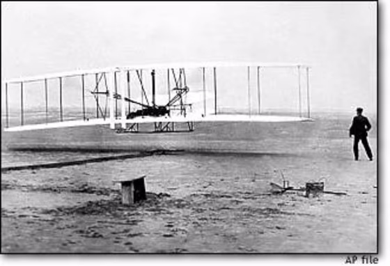 Orville Wright is at the controls of the Wright Flyer as his brother Wilbur Wright looks on during the plane's first flight at Kitty Hawk, N.C., on Dec. 17, 1903.