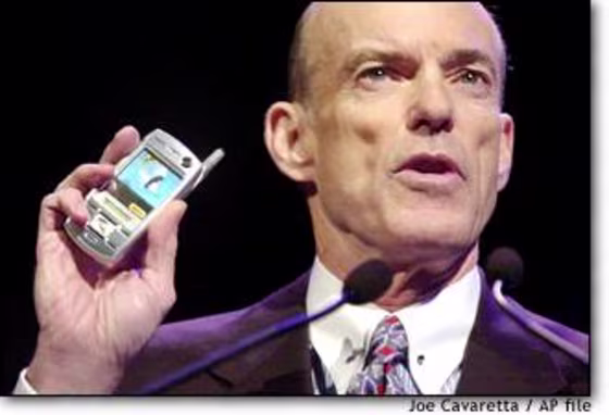 Sprint Corp. Chairman and CEO Bill Esrey holds a Sanyo phone at last year's Consumer Electronics Show in Las Vegas. Sprint ousted Esrey and another top executive after the IRS questioned their efforts to shelter stock options from taxes.