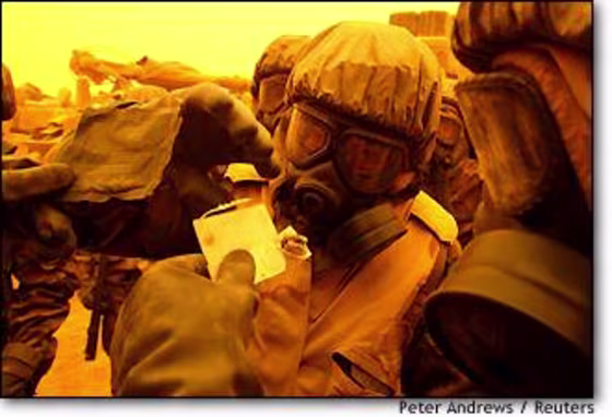 U.S. soldiers in chemical protection suits conduct a chemical detection test during a false alarm alert in a sandstorm in southern Iraq on March 26.