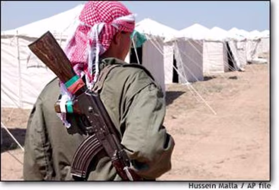 A Syrian soldier stands guard at a refugee camp on the Iraq-Syria border. The U.S. charges that high-level members of Saddam Hussein's regime are among those fleeing into Syria.