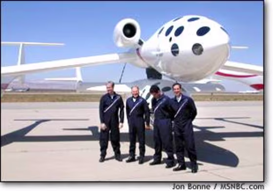 White Knight and SpaceShipOne sit on the Mojave tarmac Friday. In front, from left, are the project's pilots: Doug Shane, Mike Melvill, Peter Siebold and Brian Binnie.