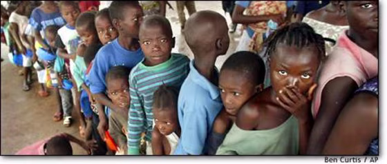 Refugee children line up Thursday to receive a spoonful of rice at the Firestone rubber plant, about 30 miles southeast of the Liberian capital, Monrovia. The plant has become a refuge for people fleeing fighting in the capital.