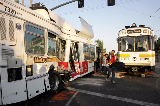 Emergency responders walk between the wreckage after a&nbsp;light-rail&nbsp;train collided with an out-of-service bus near downtown Los Angeles on Friday.