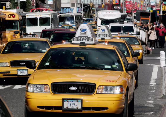 Image: Taxis drive through Times Square  in New York.