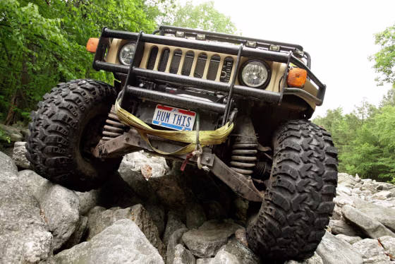 Image: John Andres drives his H1 Hummer over rocks at the Hummer Club's Straight Up or On The Rocks gathering