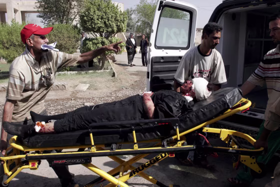 Image: A man injured in a bomb attack is transported into a hospital in Baghdad