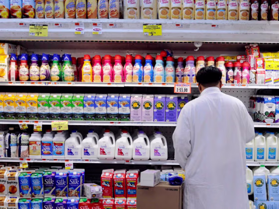 Image:  A man stocks dairy products at a supermarket i
