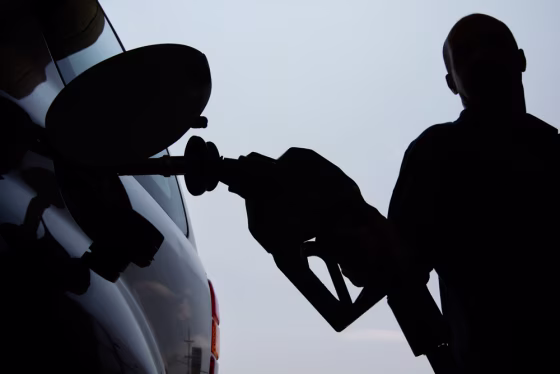 Image: A person pulls a gas pump from his vehicle