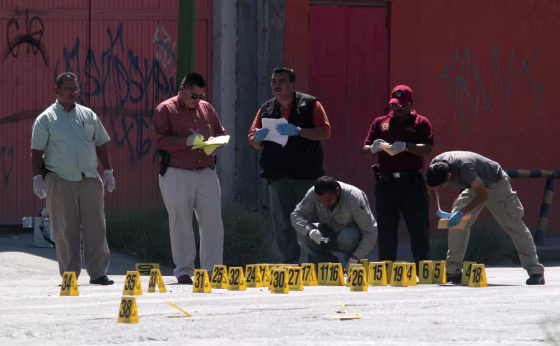 Image: Police inspect crime scene where four men were killed in drive-by shooting in the border city of Ciudad Juarez
