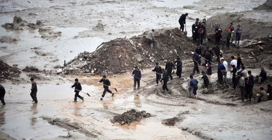 Image: Rescuers search for survivors after a mud and rock slide