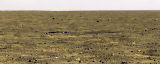 The Phoenix Mars Lander took this picture of the spacecraft's crumpled heat shield, lying about 1,000 feet (300 meters) to the south, on Sept. 16. The dark area to the right of the heat shield is a bounce mark.