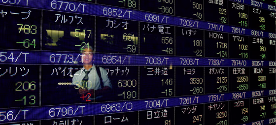 Image: A Japanese businessman looks at a stock price indicator