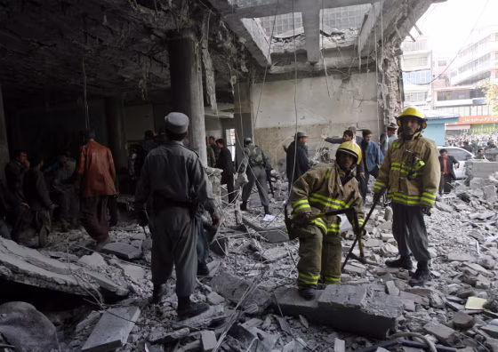 Image: Afghan policemen and firefighters work at the scene after a suicide attack in Kabul