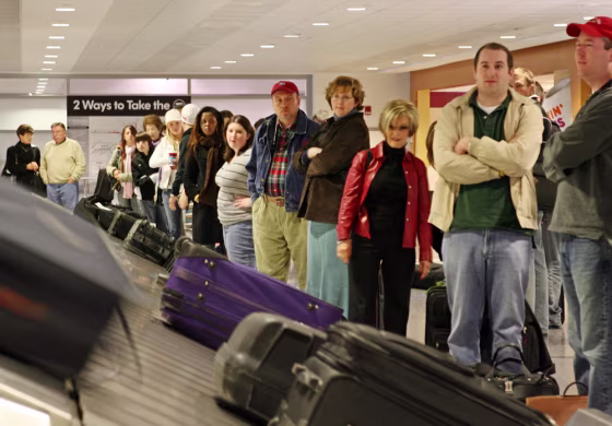 Image:Travelers wait for their bags at the baggage claim