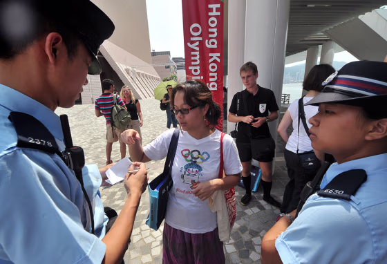 Image: A protestor is questioned by the police after demonstrating against the Beijing 2008 Olympic Games, in Hong Kong