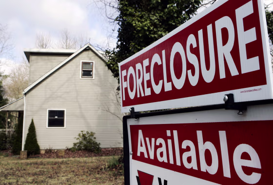 Image:  A realtor's sign is seen on the lawn of a foreclosed home