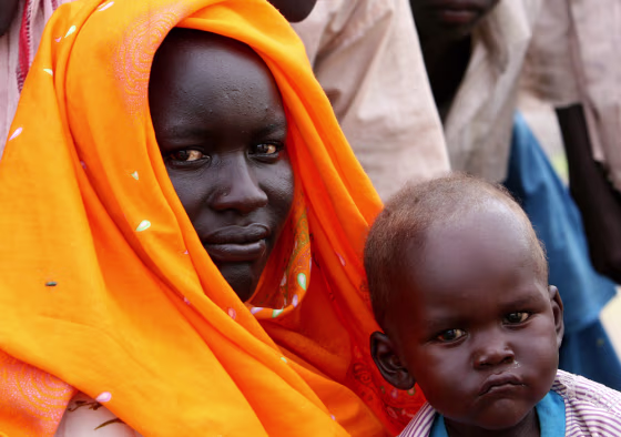 A Sudanese mother and her baby look at t