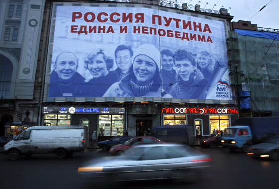 Traffic passes below an election poster for United Russia, the party that is loyal to President Vladimir Putin, in downtown St. Petersburg on Tuesday. The sign reads "Putin's Russia is united and unconquerable."