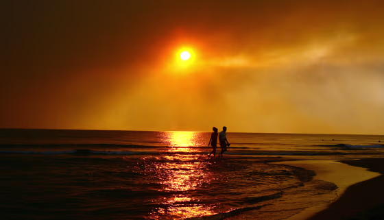 Image: People walk along a beach in Zacharo