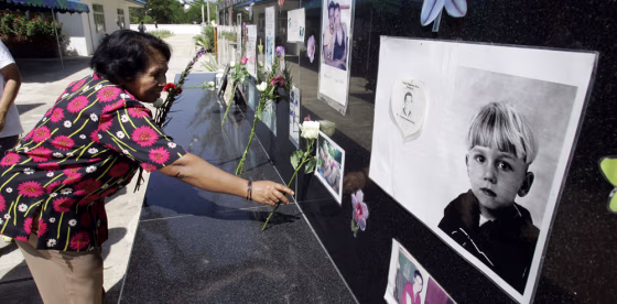 An unidentified Thai woman lays a rose in remembrance at the Tsunami Victims Cemetery in Bangmuang, Thailand, on&nbsp;Wednesday, on the third anniversary of the Asian tsunami. More than 8,000 people in Thailand were killed when the tsunami wave struck the area following a&nbsp;massive earthquake. 