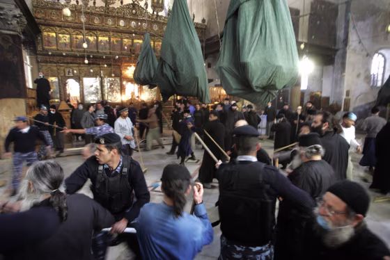 Palestinian policemen try to control a fight that erupted between Greek Orthodox deacons and Armenian priests during the annual cleaning of the Church of the Nativity in the West Bank town of Bethlehem on Thursday.&nbsp; 
