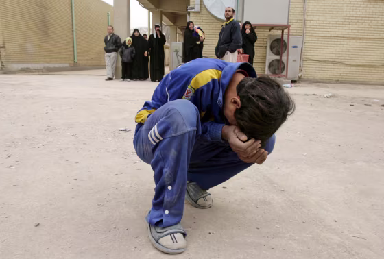 Image: An Iraqi boy cries outside a hospital morgue in Baghdad as he waits to collect his relative's body.