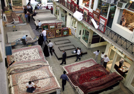 Image: Iranians browse through piles of Persian carpets