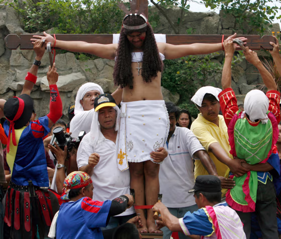 Image: Residents nail a penitent to a wooden cross.