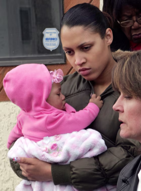 Bree Reuben, the daughter of abducted security contractor Paul Reuben, holds her daughter Ka'Leah Reuben, who was never able to meet her grandfather. Paul Reuben's first wife, Kathy Reuben, is at right.