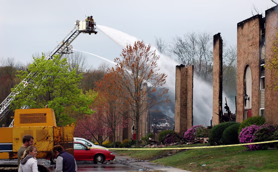 Image: Firefighters cool down the fire which destroyed the Peachtree Garden Apartments complex in Norwich, Conn.
