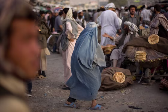 Image: A walks through a market in Kabul