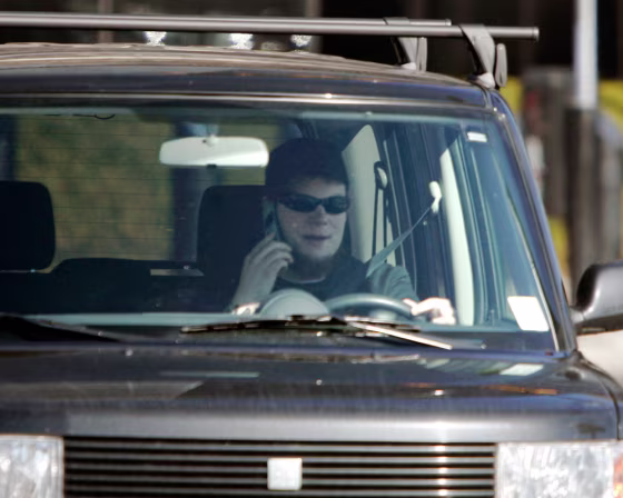 Image: A driver talks on a cell phone while driving