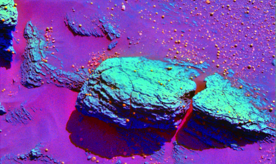 A false-color, infrared image of the rock formerly known as Snout shows the different composition of the bedrock (green) and the blueberry-style spherules (orange) near the Opportunity rover. Some spherules can be seen adhering to the&nbsp;rock, which is&nbsp;now known as&nbsp;Stone Mountain.