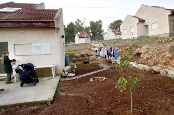 WOMEN STAND TERRACE OF THEIR HOME AT THE JEWISH SETTLEMENT OF KADIM
