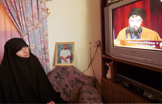 Fadila Qasfi, wife of Lebanese prisoner Jawad Qasfi, who has been&nbsp;held in Israel for 13 years, watches a televised news conference by the leader of Lebanon's militant Hezbollah group Sheik Hassan Nasrallah in her house in the southern Lebanese village of Sultaniyah on Sunday.