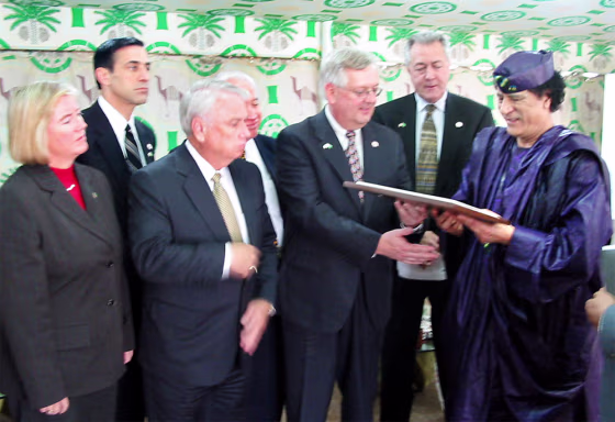 Libyan leader Moammar Gadhafi accepts a plaque from Rep. Curt Weldon, R-Pa. during a meeting with a U.S. congressional delegation in Tripoli Monday. From left are Candice Miller, R-Mich., Darrell Issa, R-Calif., Elton Gallegly, R-Calif., Solomon Ortiz, D-TX, Weldon,&nbsp;Rodney Alexander, D-La., and Gadhafi. 