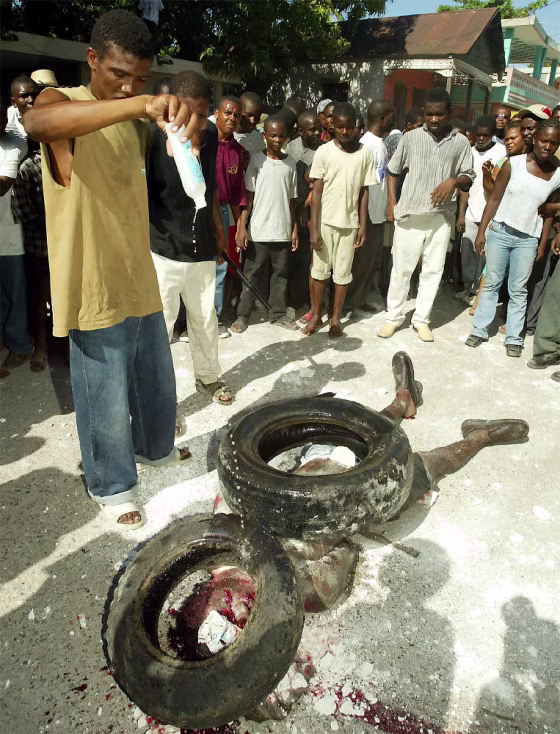 MAN POURS GASOLINE ON SUSPECTED HAITIAN ASSASSIN