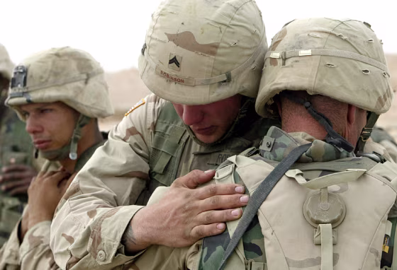 US SOLDIERS PRAY AFTER A MEMORIAL SERVICE FOR TWO FALLEN COMRADES