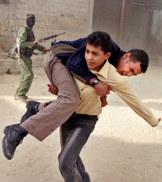 A wounded Palestinian youth is rushed from the scene following an Israeli helicopter missile strike in the Rafah refugee camp, southern Gaza Strip, Thursday.
