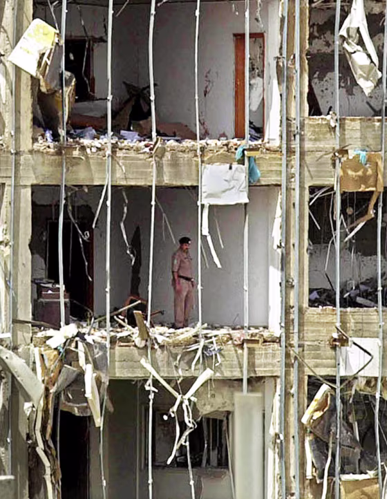 A Saudi police officer stands in the severely damaged headquarters building of the general security services Thursday in Riyadh.