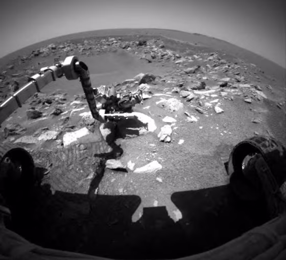 Opportunity's robotic arm reaches out to analyze a rock during Sol 87 of its mission on Mars. The rover has now completed the initial 90-day phase of its sojourn.